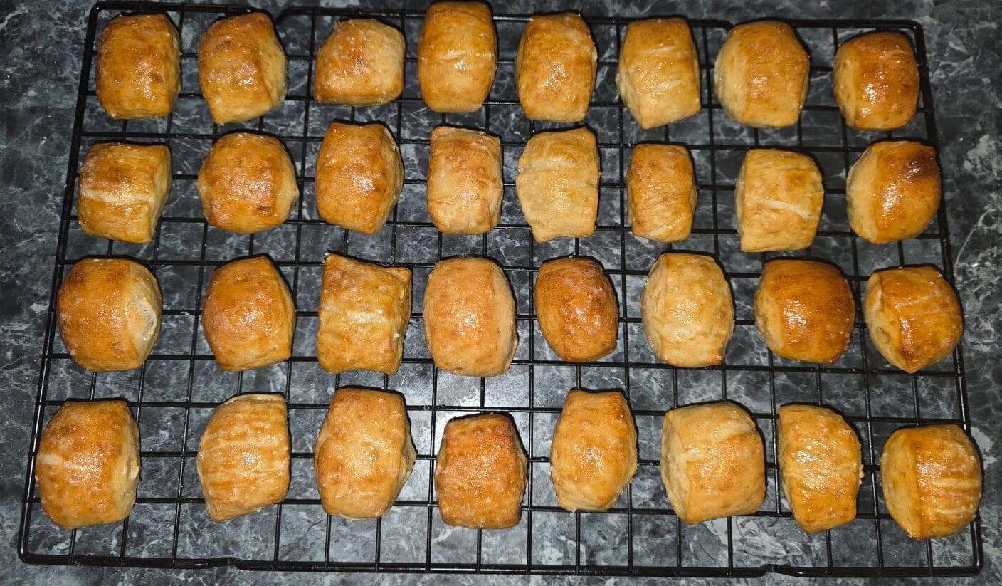 Rows of golden sourdough pretzel bites on a cooling rack